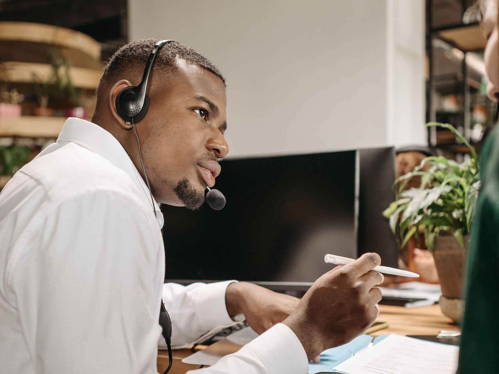 Ingénieur support avec un casque aidant une cliente