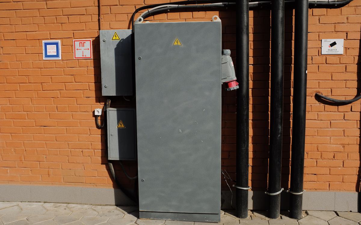 Armoires électriques fixées sur un mur en briques