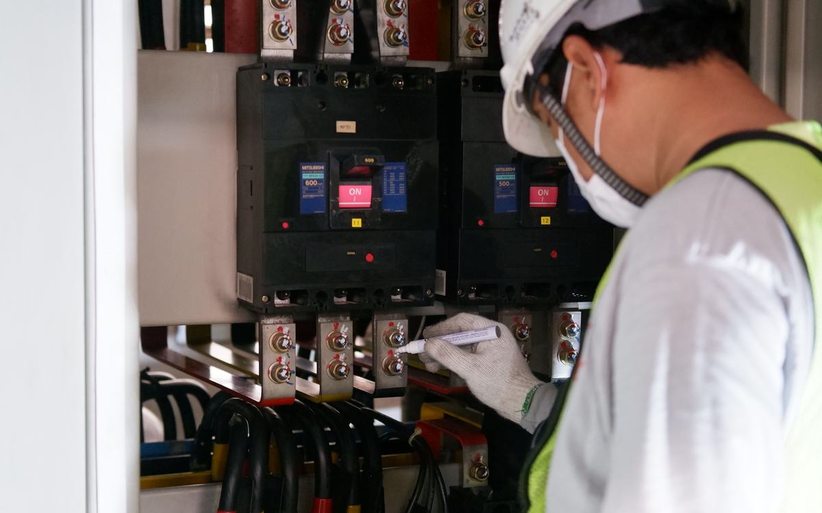 Électricien vérifiant les disjoncteurs d’un tableau de distribution